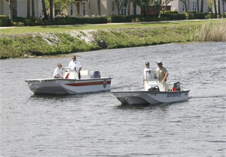 Officials in Delray Beach, Fla., search a canal for evidence on Thursday after two children were discovered dead there, their bodies stuffed into luggage.